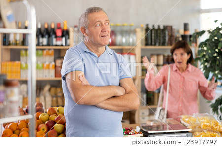 Elderly woman quarrels with man in grocery store 123917797
