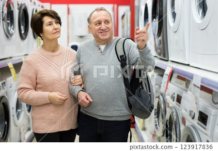 Happy spouses of mature age choose a washing machine Happy spouses of mature age choose a washing machine 123917836