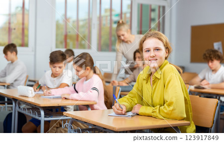 Young girl studying in school with classmates 123917849