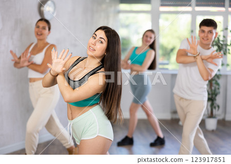 Girl teen perform choreographic exercise and teach energetic mobile social dance groove with friends Girl teen perform choreographic exercise and teach energetic mobile social dance groove with friends 123917851