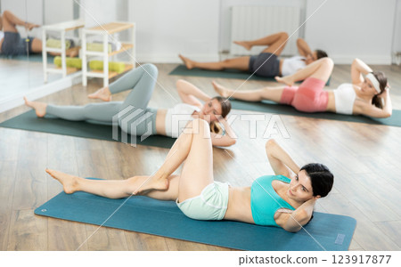 Young girls doing press exercise in pilates studio 123917877