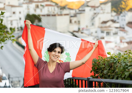Happy latin american woman posing outdoors with national flag of Peru 123917904