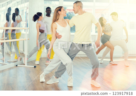 Young woman dances incendiary tango with man partner during choreography lesson 123917918