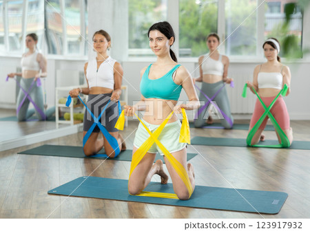 Group of young women doing pilates with band 123917932