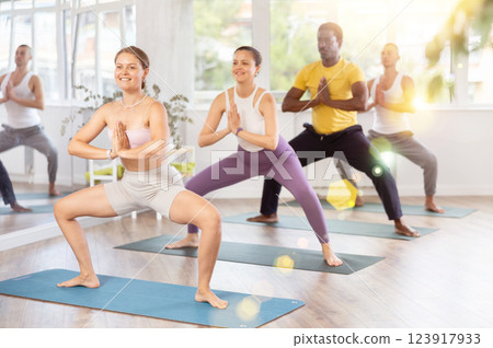 Group of men and women doing yoga in studio Group of men and women doing yoga in studio 123917933