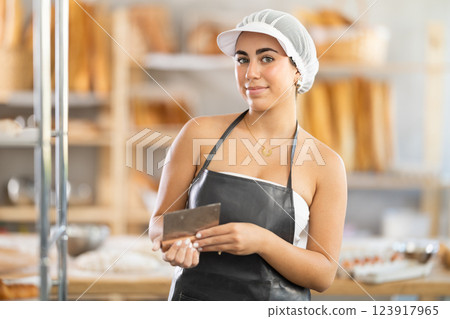Young baker proudly holds a dough cutter 123917965
