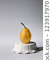 Ripe pear standing on an inverted bowl 123917970
