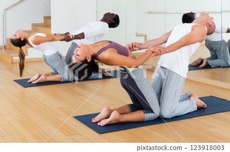 Scene of a group of people practicing couples yoga Scene of a group of people practicing couples yoga 123918003