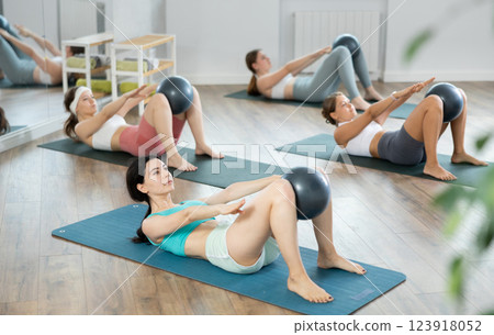 Group of young women doing pilates with softball Group of young women doing pilates with softball 123918052