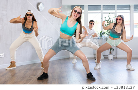 Teenage girl practicing hip-hop movements during group dance class Teenage girl practicing hip-hop movements during group dance class 123918127