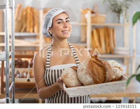 Young woman seller with bread in basket Young woman seller with bread in basket 123918151