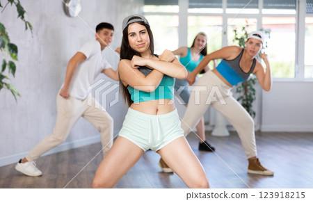 Emotional teen girl dancing krump with group in modern studio Emotional teen girl dancing krump with group in modern studio 123918215