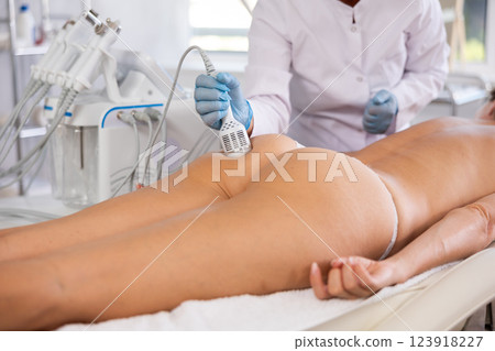 Hardware anti-cellulite procedure on butt of young woman in beauty clinic 123918227
