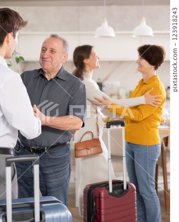 Friendly father-in-law shaking hand with son-in-law returning from trip 123918243