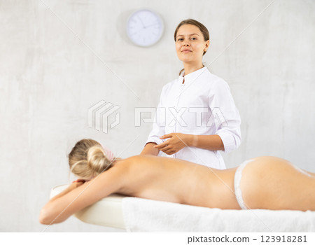 Successful young female massage therapist standing in procedure room Successful young female massage therapist standing in procedure room 123918281
