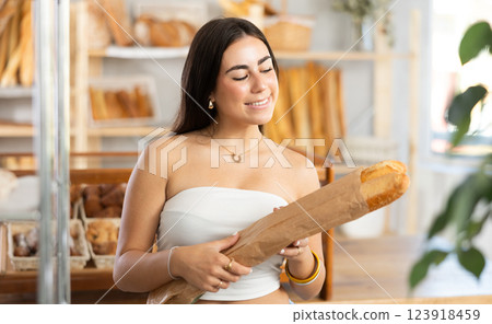 Young woman buying baguettes in bakery 123918459