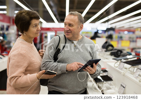 Senior couple choosing tablet in tech store Senior couple choosing tablet in tech store 123918468