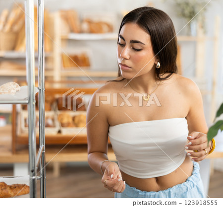 Young woman looking around in bakery 123918555
