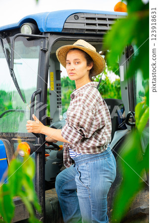 Middle age female working on a tractor at orchard 123918631