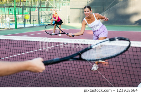 Young woman in shorts playing tennis on court Young woman in shorts playing tennis on court 123918664