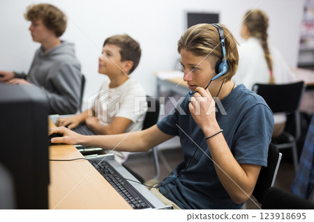 Portrait of a fifteen-year-old schoolboy in headphones at a computer 123918695