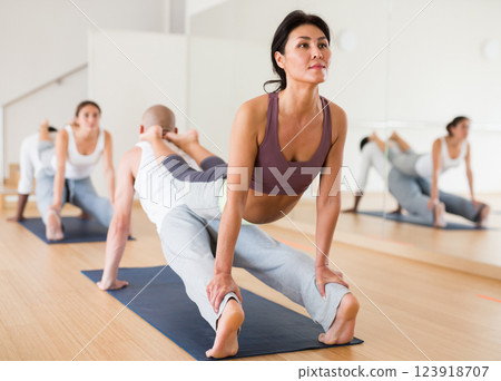 Asian woman exercising assisted yoga poses in pair in yoga studio 123918707