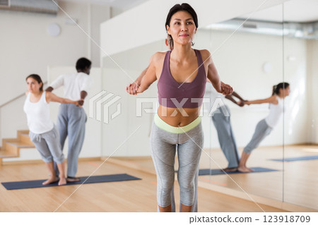 Asian woman practicing couple yoga positions with male partner 123918709