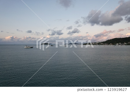Calm waters and boats at sunset near a coastal village Calm waters and boats at sunset near a coastal village 123919627