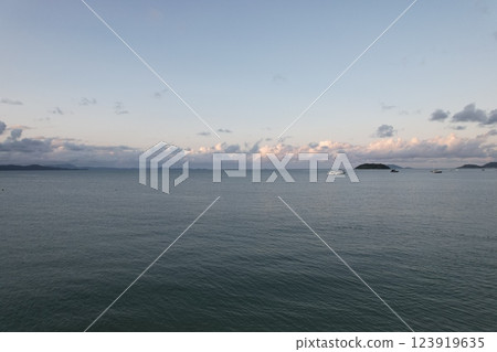 Tranquil coastal landscape at dusk with boats in the distance 123919635