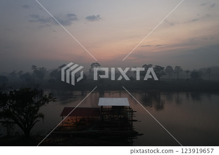 Tranquil morning by the river with mist over water and trees 123919657
