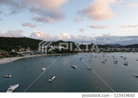Boats anchored in a tranquil bay during sunset near coastal hills 123919680
