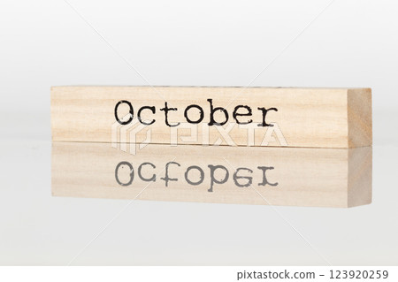 wooden cube with an inscription October on a white background 123920259