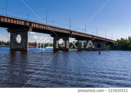 Bridge on a river against a blue sky and clouds 123920331