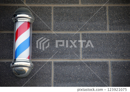 Classic Barbershop Pole on Brick Wall Background 123921075