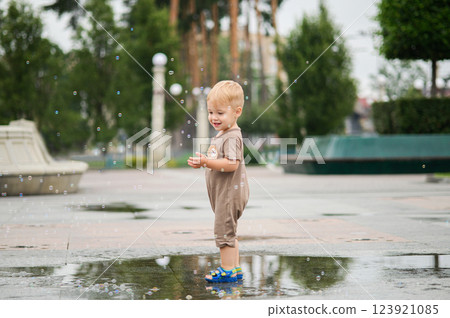 Toddler Playing in a Rain Puddle Outdoors 123921085