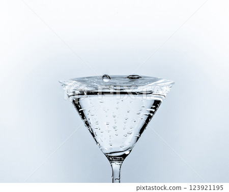Close-up of water drop falling into a glass on white background 123921195