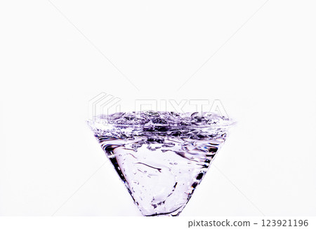 Close-up of water drop falling into a glass on white background 123921196