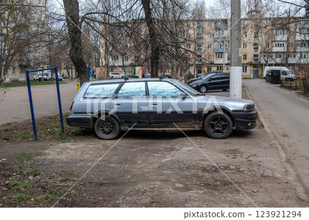 An old silver car.An old car is parked in the yard, attracting attention due to its survivability. An old silver car.An old car is parked in the yard, attracting attention due to its survivability. 123921294