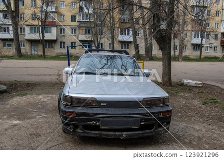 An old silver car.An old car is parked in the yard, attracting attention due to its survivability. An old silver car.An old car is parked in the yard, attracting attention due to its survivability. 123921296