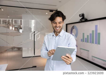 Cheerful project manager man enjoying modern neural technology on tablet 123921699