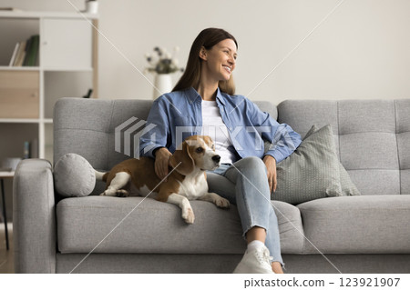 Dreamy wellbeing woman resting with lovely beagle dog at home Dreamy wellbeing woman resting with lovely beagle dog at home 123921907