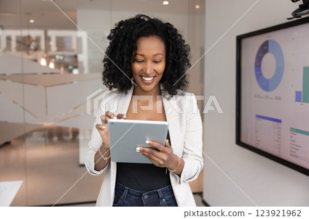Positive beautiful African businesswoman working on financial marketing report Positive beautiful African businesswoman working on financial marketing report 123921962
