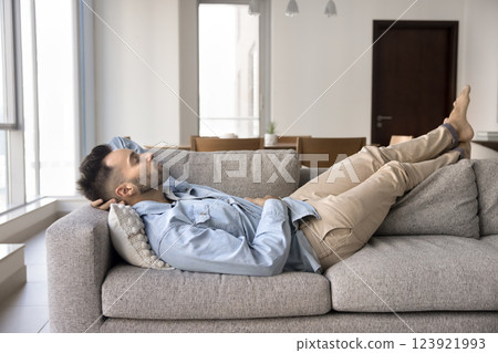 Hispanic man sleeping lying on comfortable sofa in living room 123921993