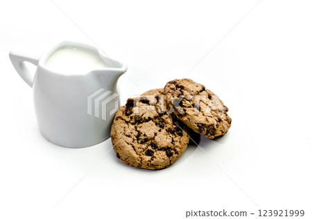 Close-up of homemade chocolate chip cookies with a jug of milk isolated on white background. 123921999