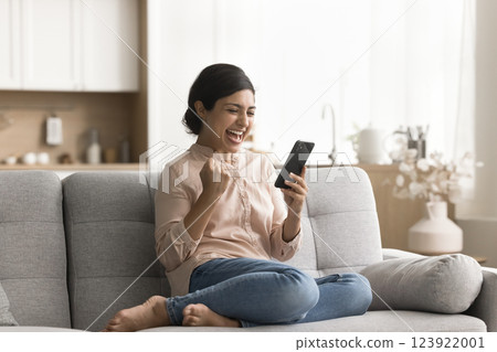 Excited young woman scream yes looking on smartphone screen Excited young woman scream yes looking on smartphone screen 123922001