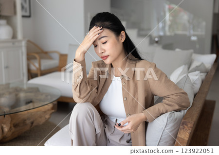 Frustrated depressed young Asian woman touching head Frustrated depressed young Asian woman touching head 123922051