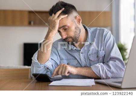 Young 30s Hispanic man feels stressed due to financial issues Young 30s Hispanic man feels stressed due to financial issues 123922140