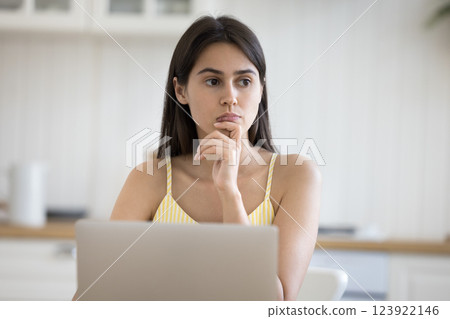 Young lady distracted from work on notebook with pensive look 123922146