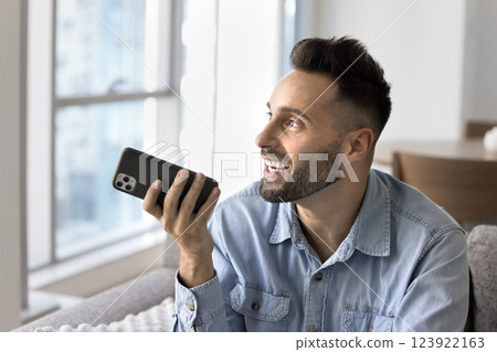 Man holding smartphone lead talk using speakerphone Man holding smartphone lead talk using speakerphone 123922163
