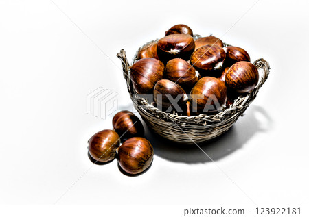 Chestnuts in wicker basket on white background 123922181